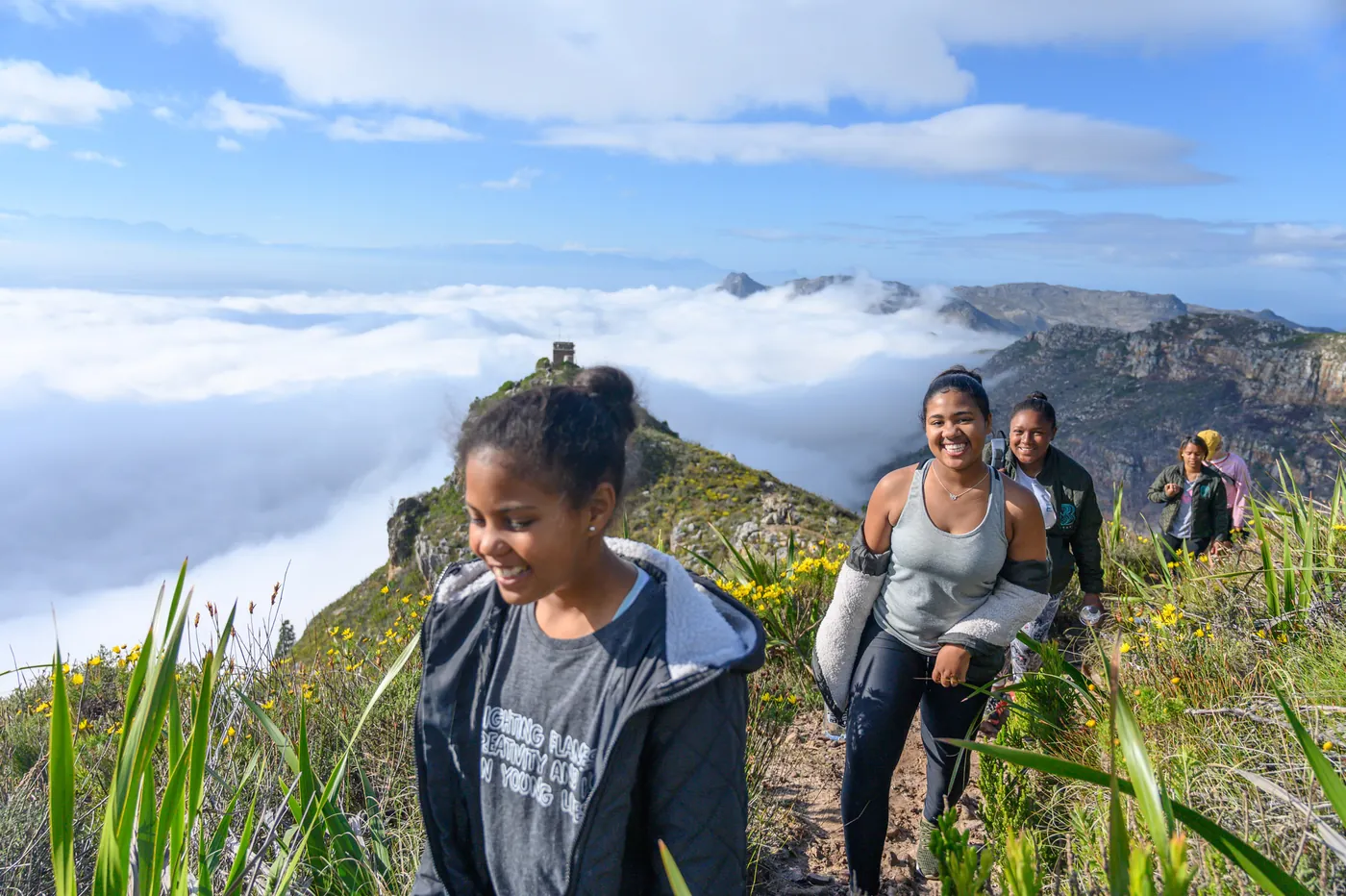 BRAVE girls hiking above the clouds on a mountain trail