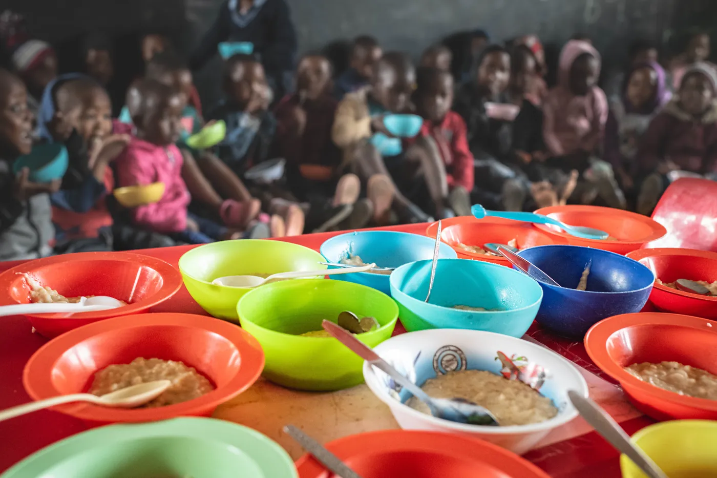 Rows of colourful bowls of porridge laid out for children at Siyabonga