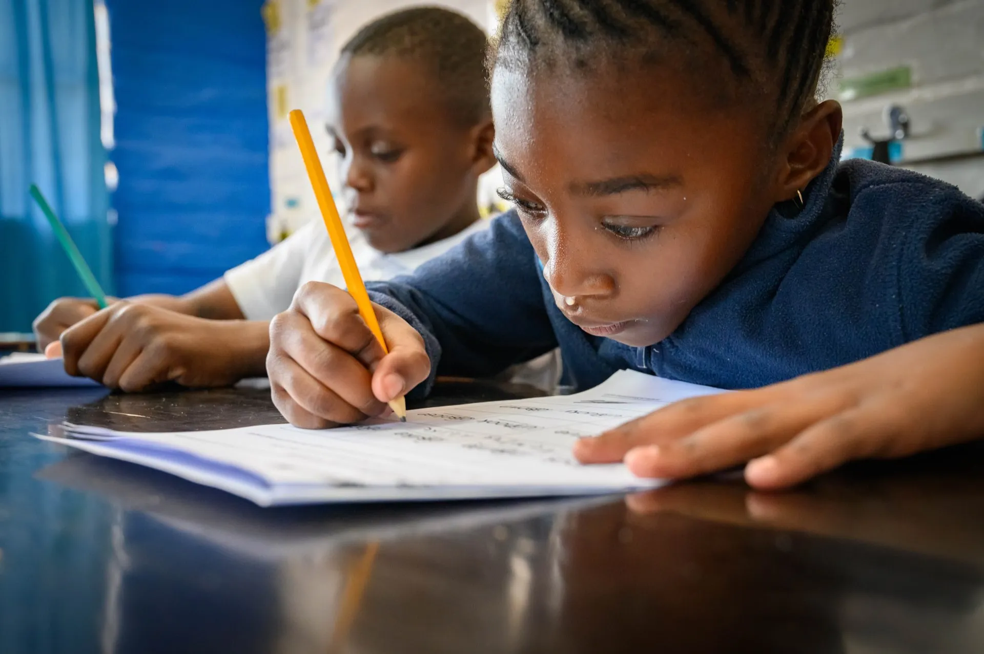 A girl writing in her workbook, focused and absorbed