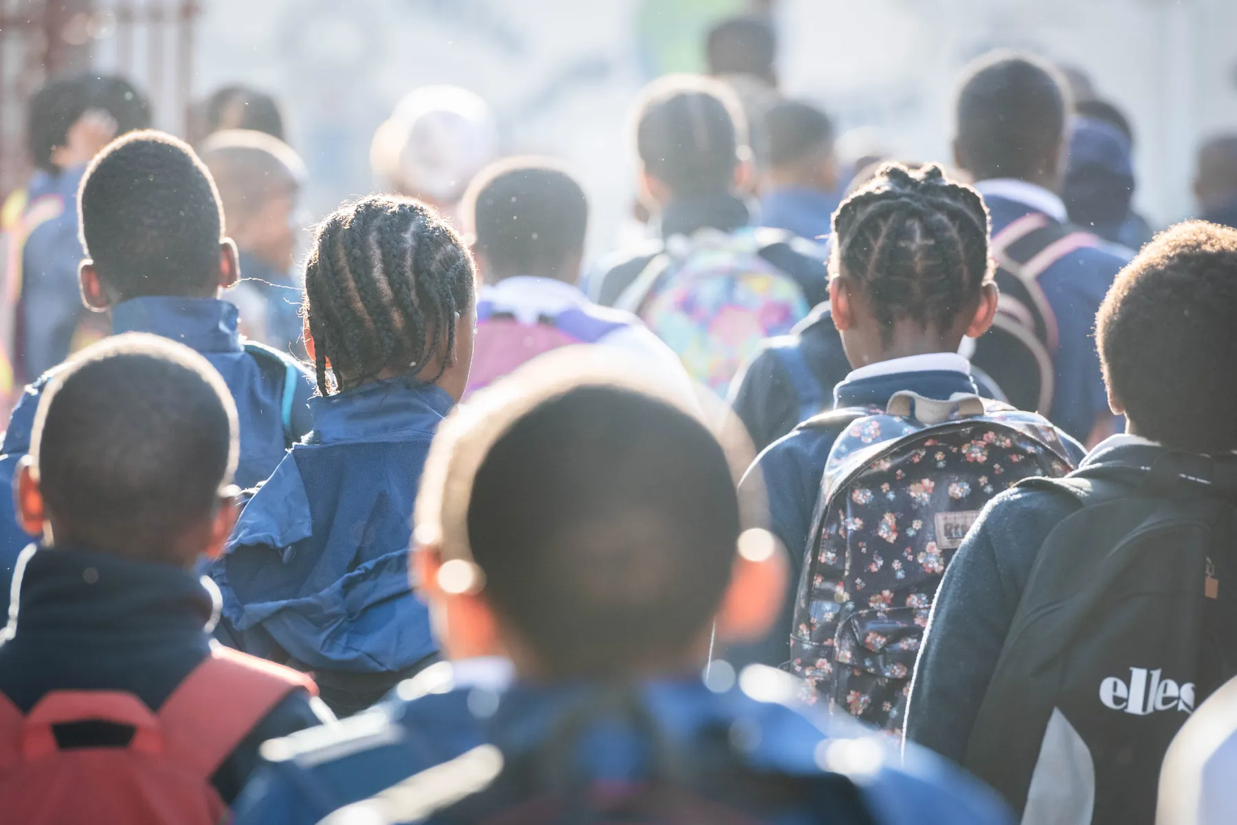 Kgololo Academy learners in their school jackets and backpacks heading into school