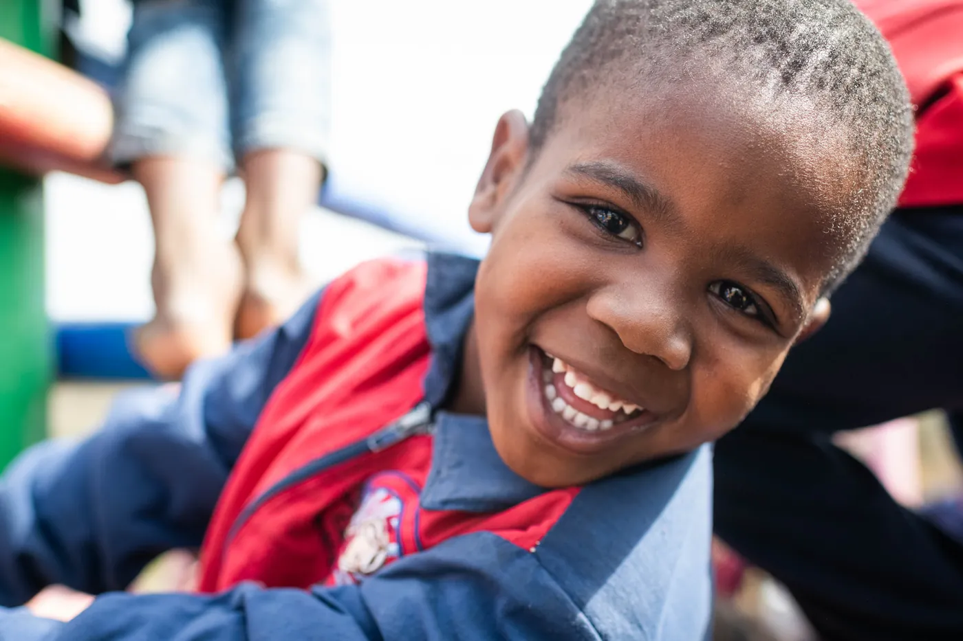 A boy smiling on the playground at Siyabonga