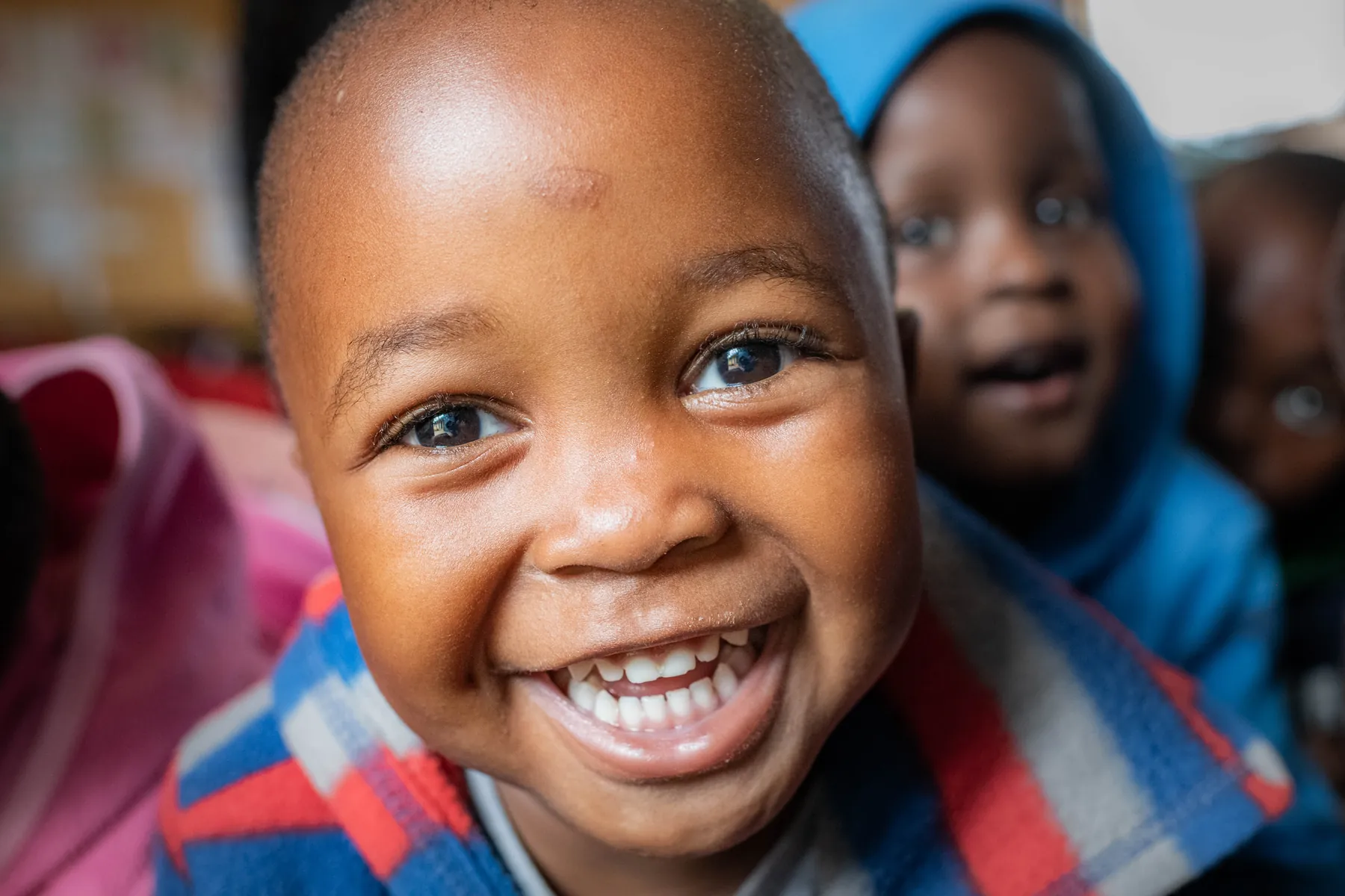 A boy beaming at the camera at Siyabonga