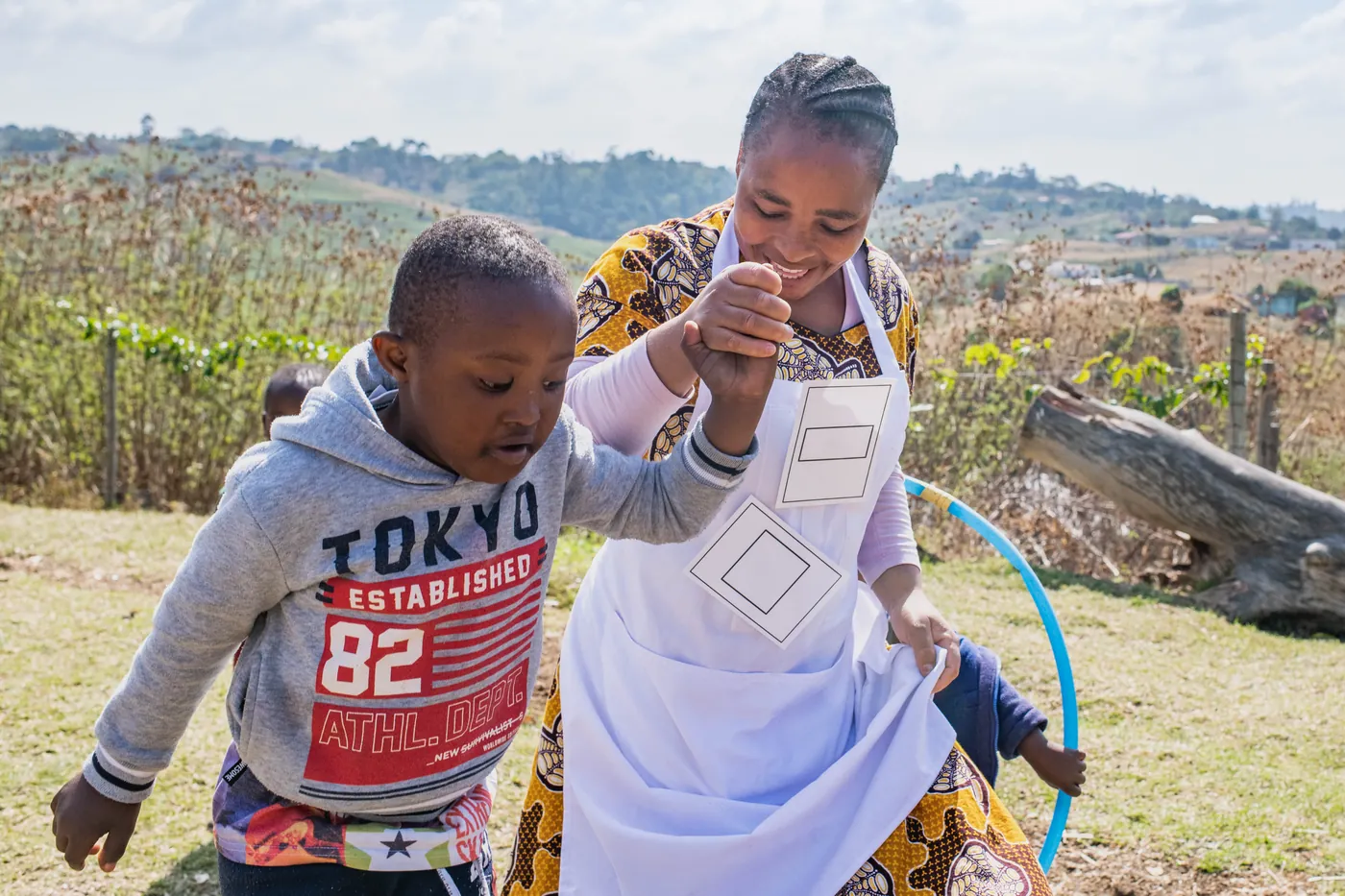A Siyakwazi practitioner walking with a young boy outdoors