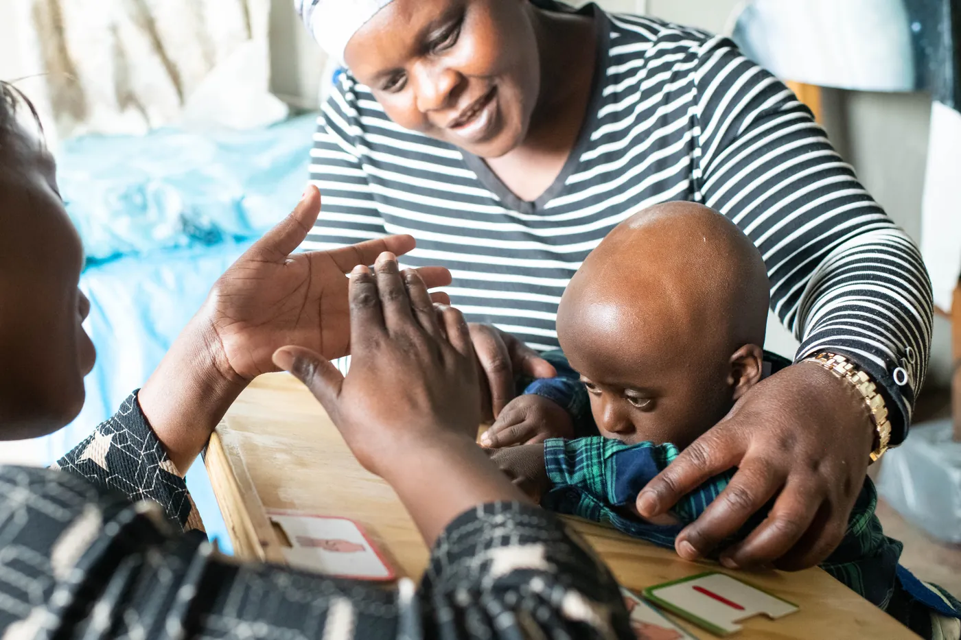 A Siyakwazi therapist guiding a child through a hands-on activity