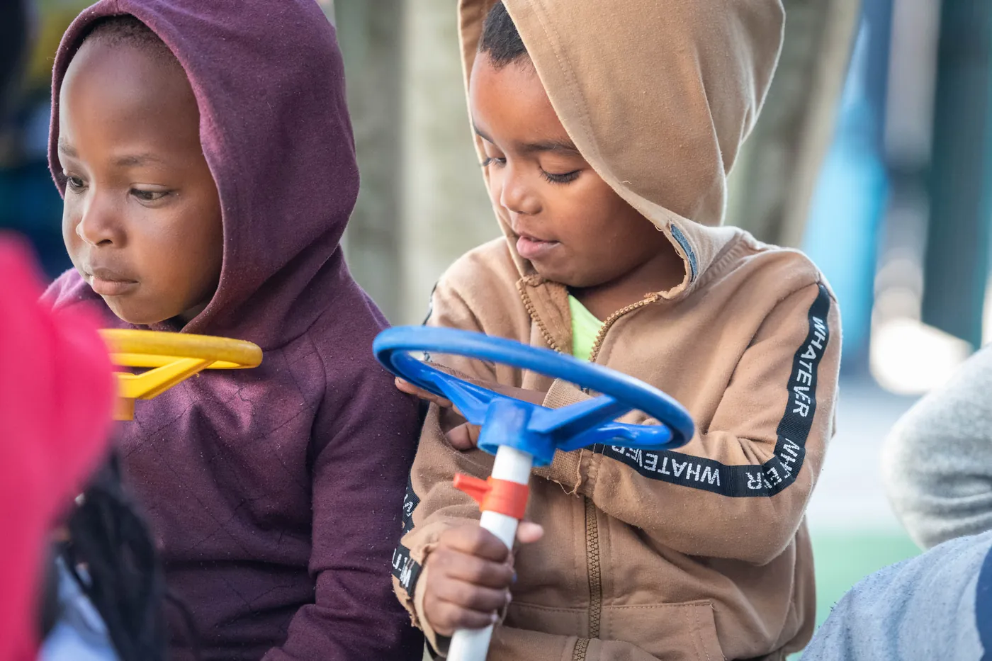Two toddlers playing with a toy steering wheel at a True North centre
