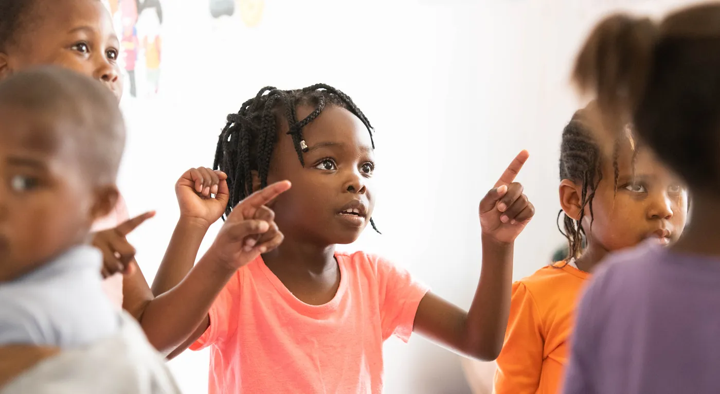 A girl pointing as her classmates join in at a True North centre